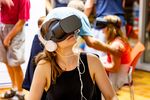 Eine junge Frau mit VR-Brille und Kopfhörern