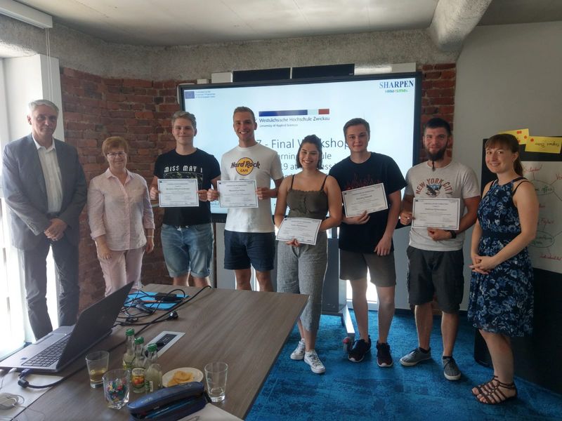 Gruppenfoto: Teilnehmer des Sharpen Programmes stehen mit zwei Professoren zusammen und halten ihre Teilnahmeurkunden in den Händen.