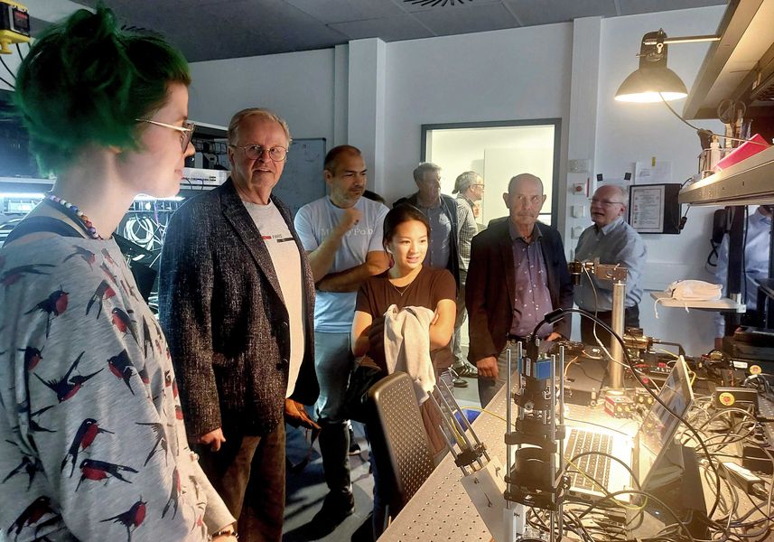 Mitglieder des Zwickauer Stadtrats besichtigen ein Labor zur optischen Messtechnik. 