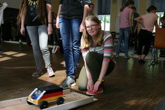 Foto: Eine Schülerin lässt ihr Modellauto eine Rampe mit Anstieg hoch fahren.