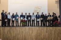 Gruppenfoto: Die Absolventen stehen aufgereiht und präsentieren ihre Urkunden mit den Gratulanten.