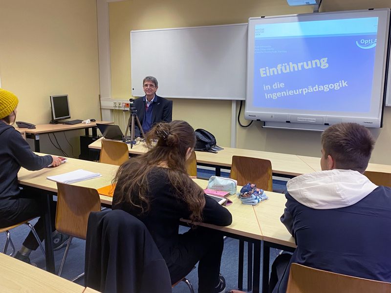 Professor blickt auf seine Studenten, die in den Bänken sitzen
