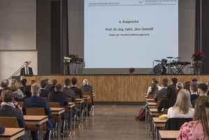 Foto: Absolventen sitzen in der Aula Scheffelberg. Am Rednerpult Prof. Dr. Jörn Getzlaff.