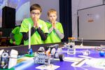 Foto: Zwei Schüler an einem Tisch mit Minirobotern zur First Lego League.