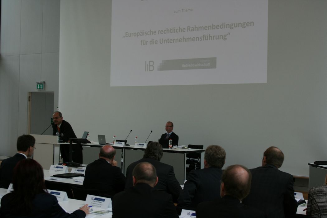 Foto: Ein Redner hält einen Vortrag am Rednerpult.