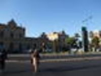 Foto: Blick über eine doppelspurige Straße auf das Bahnhofsgebäude der Stadt Huelva.