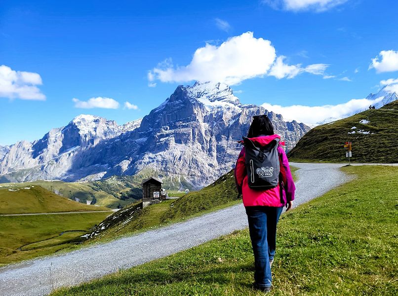 Eien Person spatziert vor einer Bergkulisse 