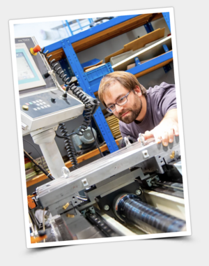 Mann mit Brille an einer Maschine im Labor