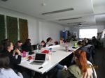Foto: Blick in einen Konferenzraum. Studierende sitzen an einem Konferenztisch und führen ein Meeting.