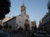Foto: Eine Kirche mit Personen vor dem Eingangsbereich.