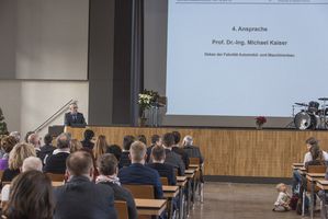 Foto: Absolventen sitzen in der Aula Scheffelberg. Am Rednerpult Prof. Dr. Michael Kaiser.