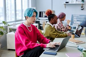 Foto: Personen sitzen in einem Büro an Laptops und Rechnern (Quelle: AdobeStock)