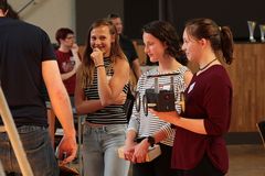 Foto: Drei Schülerinnen stehen wartend in der Aula am Scheffelberg. Eine Schülerin hält ein Solar Modellauto in der Hand.