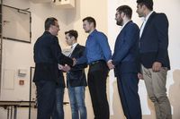 Foto: Fünf Absolventen erhalten eine Gratulation und bekommen ihre Urkunden überreicht.