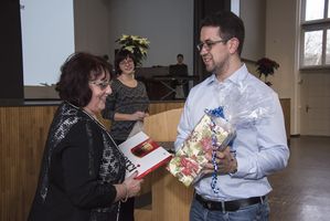 Foto: Eine Frau bekommt ein Präsent überreicht.