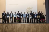 Gruppenfoto: Die Absolventen stehen aufgereiht mit den Gratulanten und präsentieren ihre Urkunden.