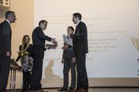 Foto: Zwei Absolventen bekommen ihre Urkunden überreicht.