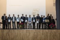 Gruppenfoto: Die Absolventen stehen aufgereiht mit den Gratulanten und präsentieren ihre Urkunden.