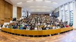 Blick von vorn in einen vollbesetzten Hörsaal.