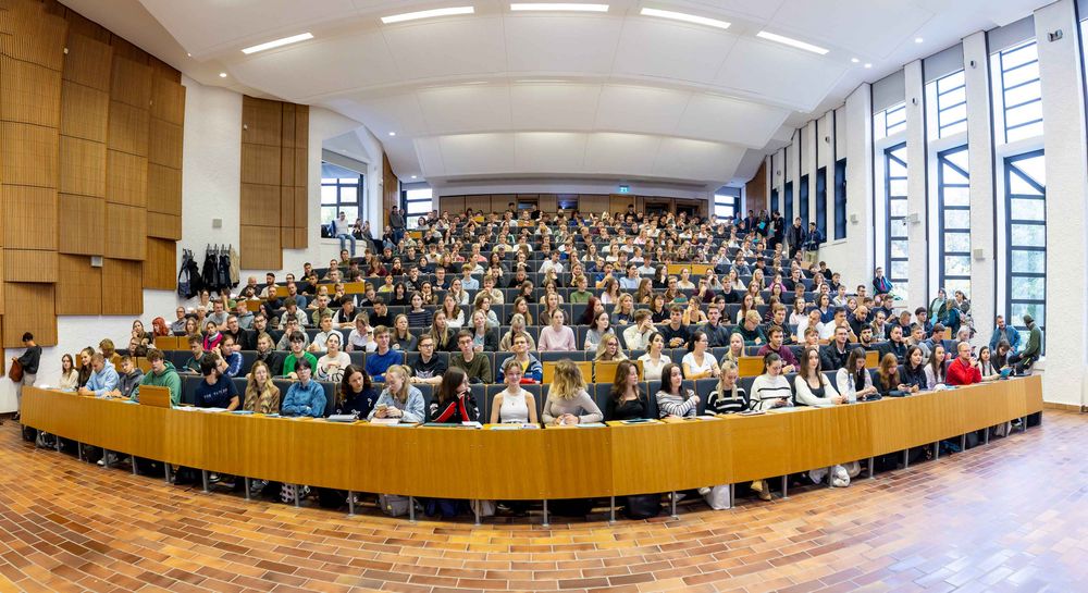 Blick von vorn in einen vollbesetzten Hörsaal. 