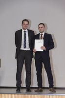 Foto: Ein Absolvent mit Zeugnis und Professor.