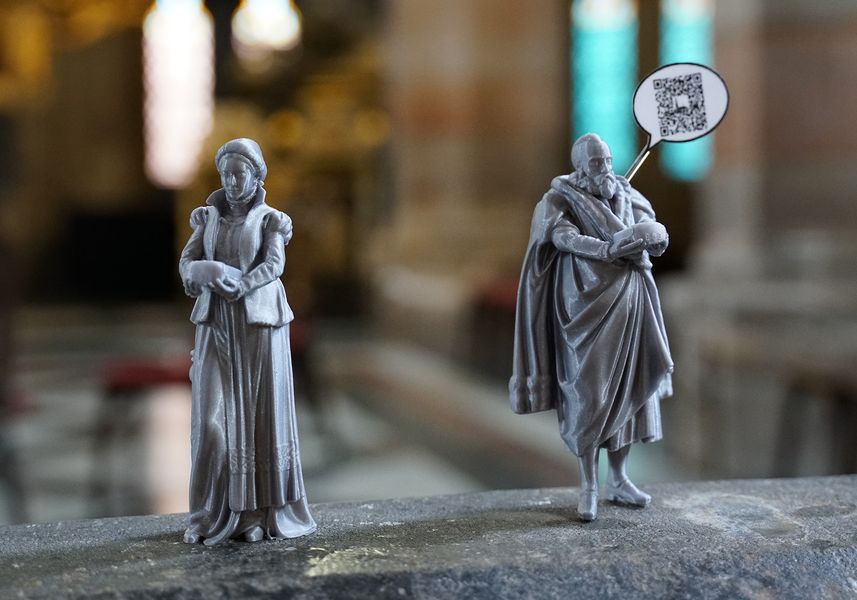 Zwei Miniaturfiguren, eine hat einen QR-Code. 