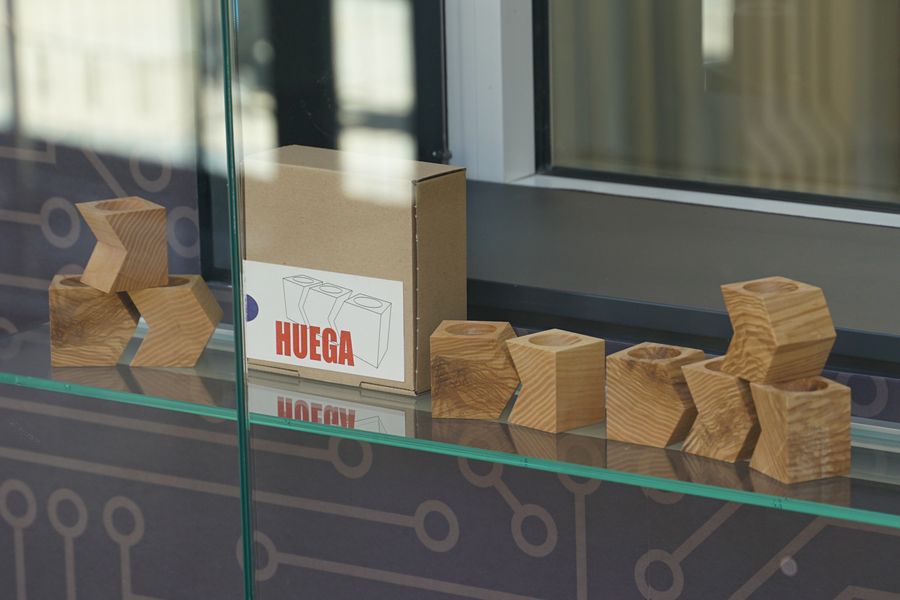 Auf dem Bild sind die HUEGA-Holz-Eierbecher auf einem Glasregal zu sehen.