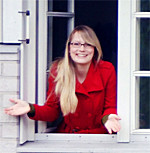 Foto: Eine Studentin schaut aus einem Fenster. Erster Abschluss im internationalen Studienprogramm Double Degree Fashion Design