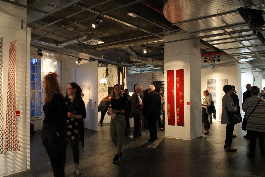 Foto: Besucher laufen durch die Ausstellung Tuchfühlung.