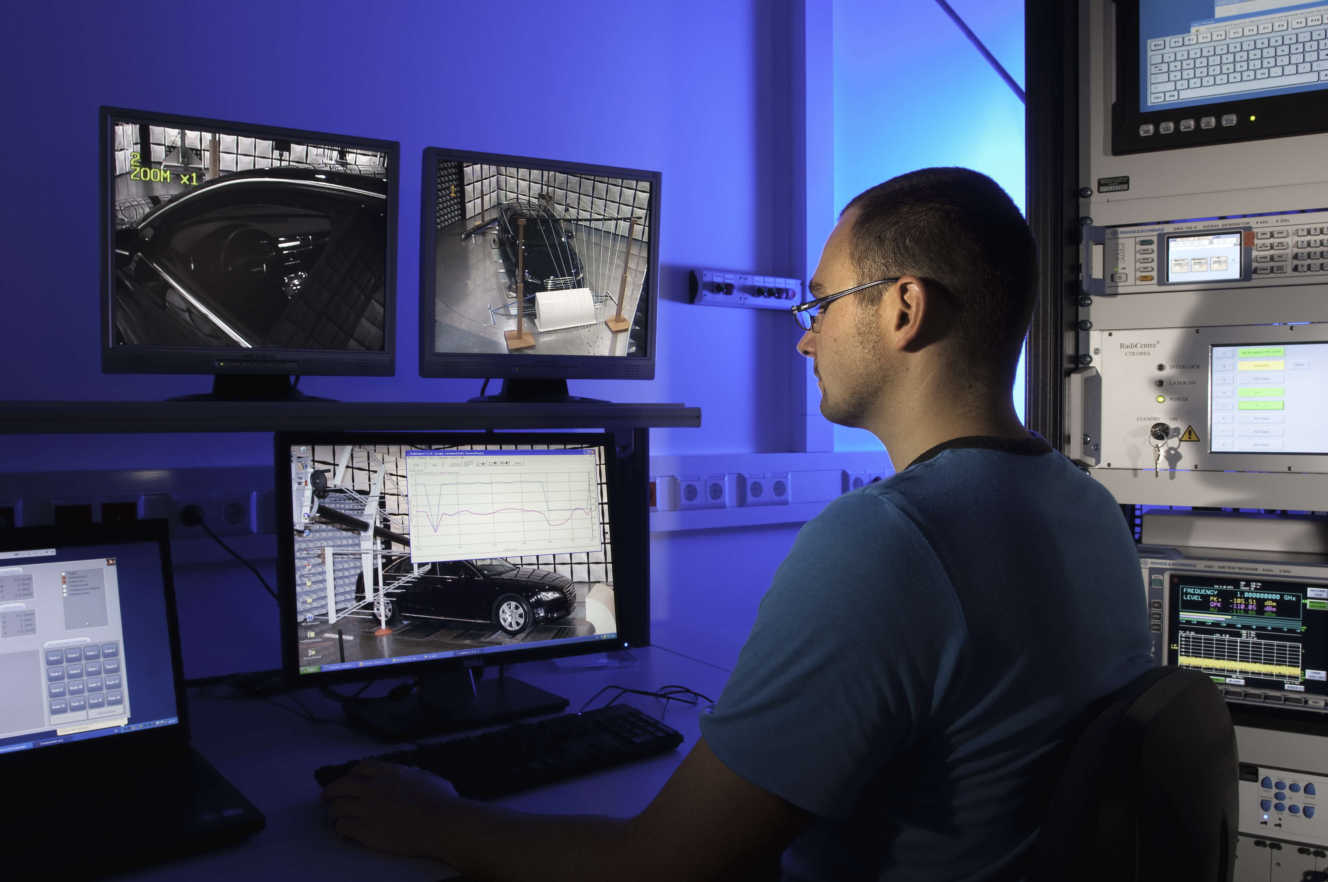 Ein Mitarbeiter sitzt an einem PC und überwacht den Versuchsstand