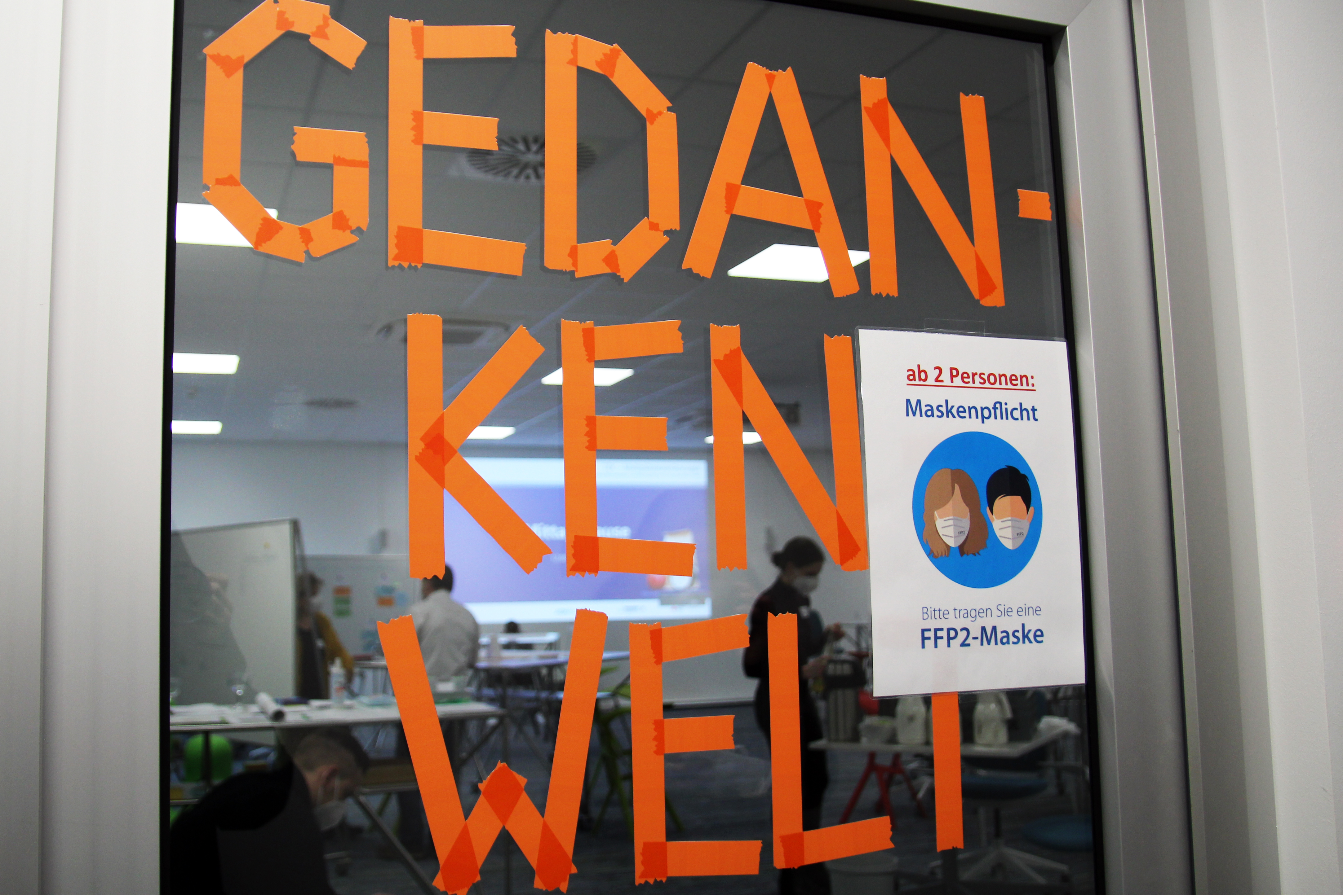 Foto: Glasscheibe mit aufgeklebten Buchstaben "Gedankenwelt"