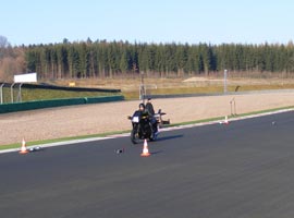 Foto 1: Vorbeifahrt eines Motorrades auf einer Teststrecke.