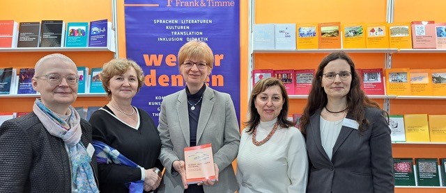 Foto: fünf Frauen halten ein Buch in die Kamera