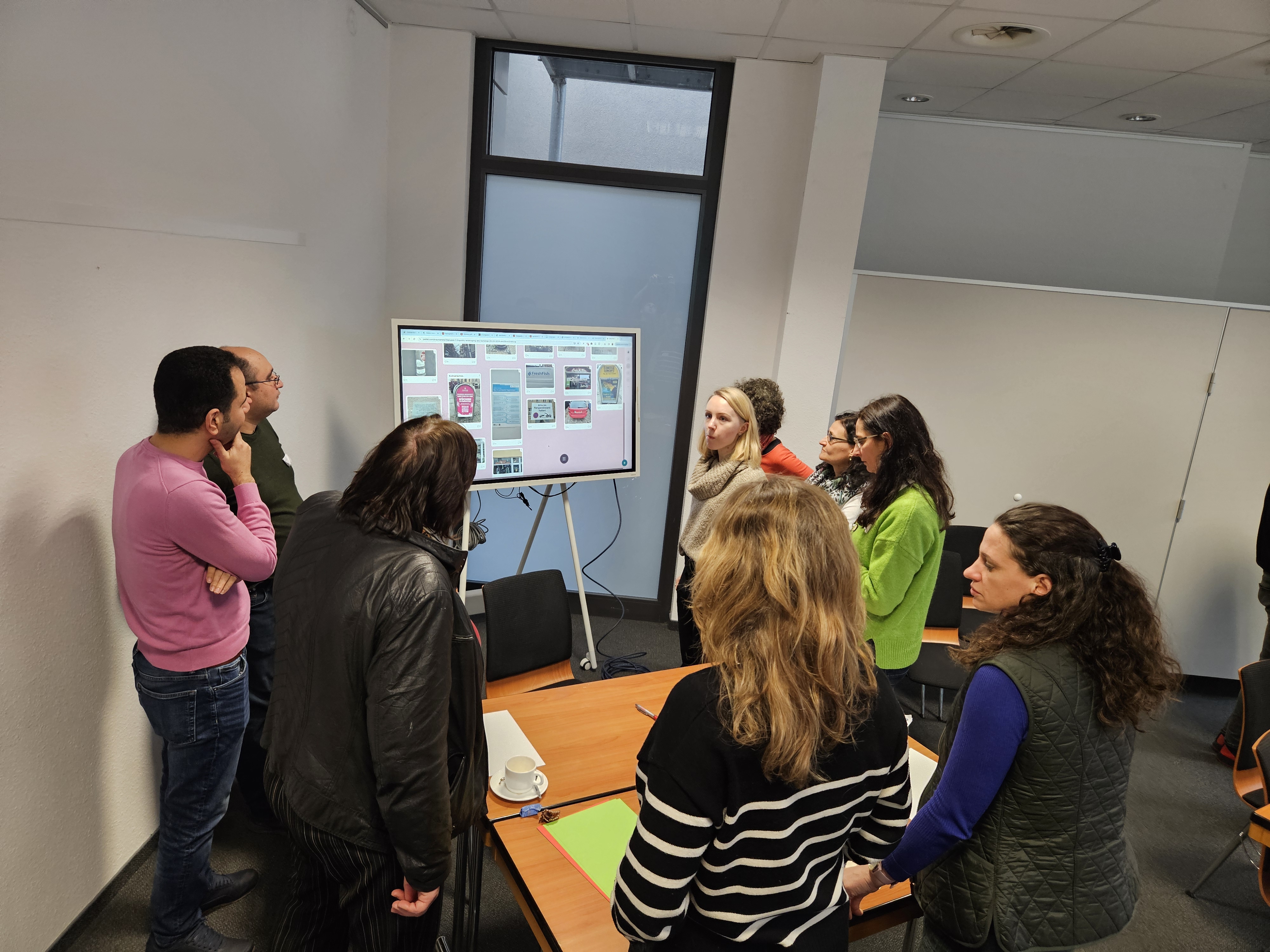 Foto: Gruppe von Menschen stehen um einen Bildschirm