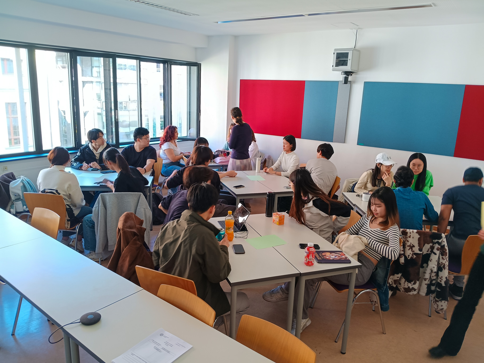 Foto: Studierende an verschiedenen Tischen tauschen sich aus