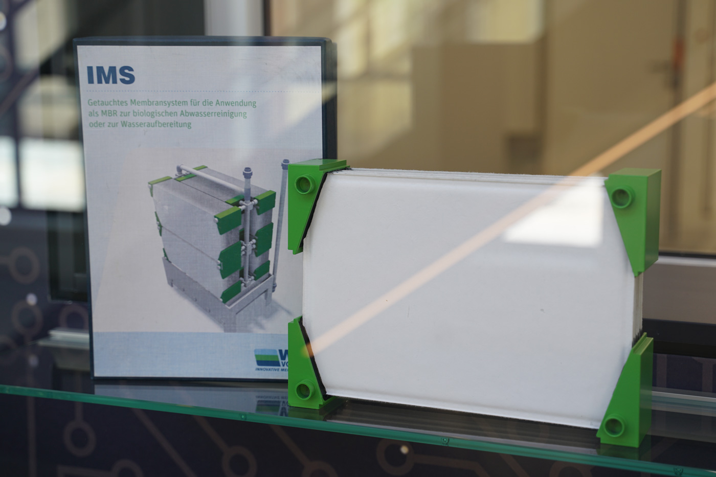 Auf dem Foto ist ein Teil des Membransystems mit seiner Verpackung auf einem Glasregal zu sehen.