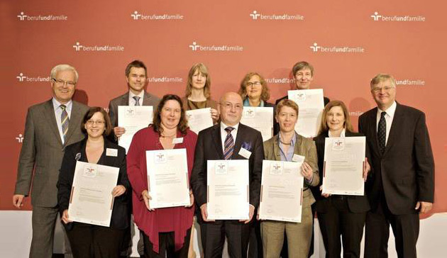Gruppenfoto: Frau Prof. Rosenbaum nimmt das Zertifikat stellvertretend entgegen. Es sind noch weitere Menschen auf dem Bild zu sehen.