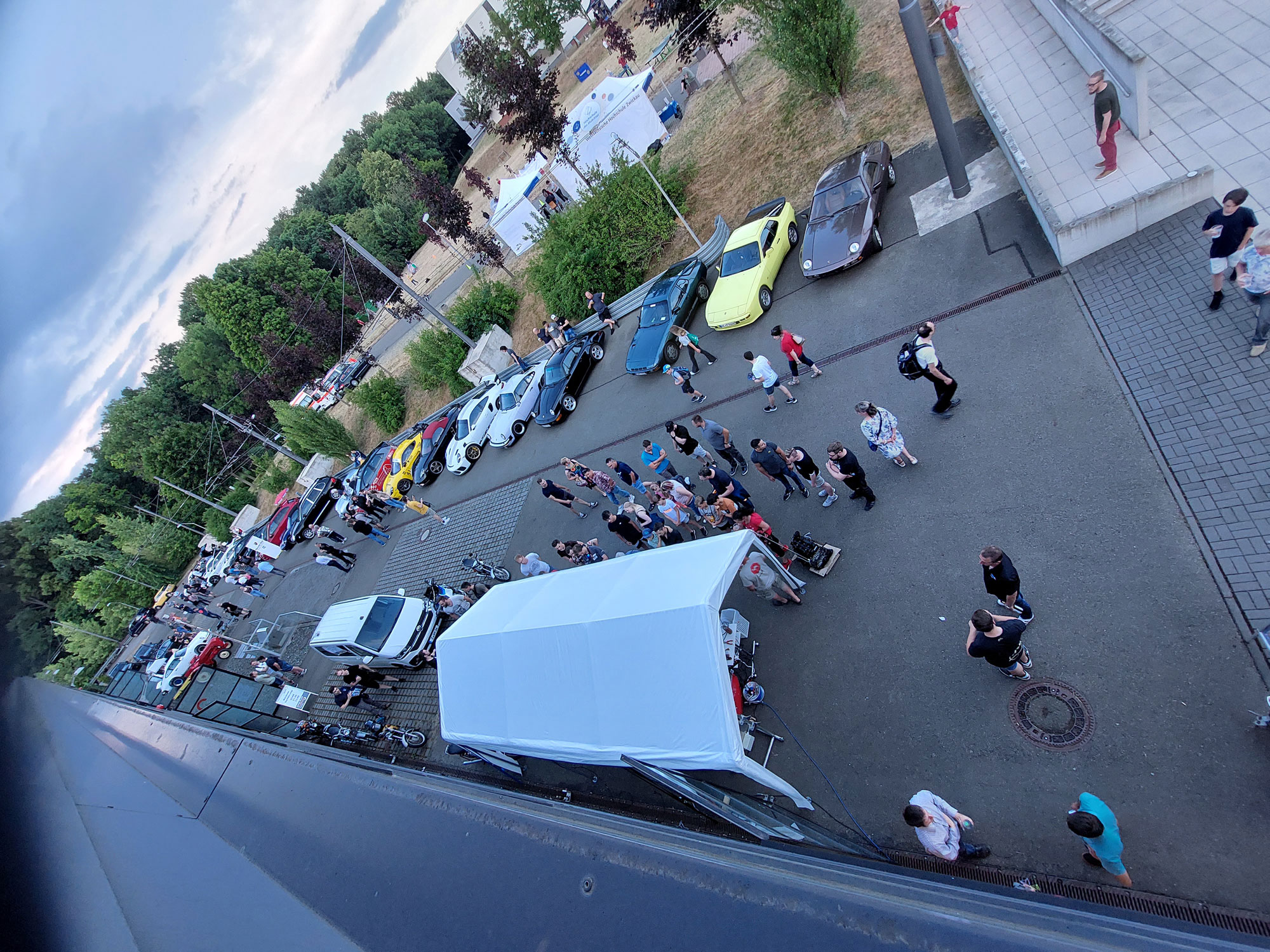 Foto: zu sehen sind viele Besucher am Pavillon der Zweirad-Leistungsmessung und vor den in einer Reihe aufgestellten Porsches an der Seite des August Horch Baus (AHB) zur Lange Nacht der Technik, aufgenommen vom Dach des AHB | Quelle:WHZ