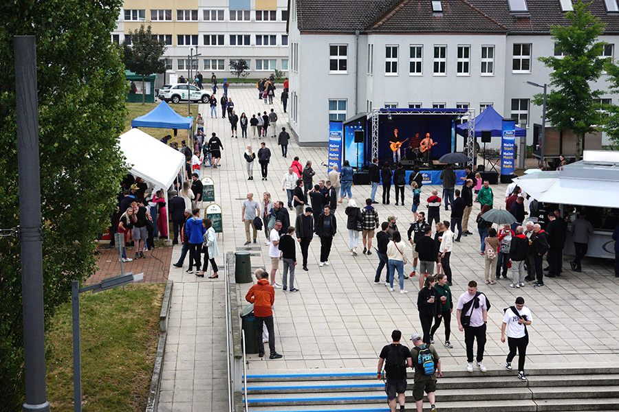 Ein Foto vom Dach des August-Horch-Bau über den Campus zur "Langen Nacht der Technik". Zu sehen sind Stände und die Bühne in Mitten vieler Besucher.