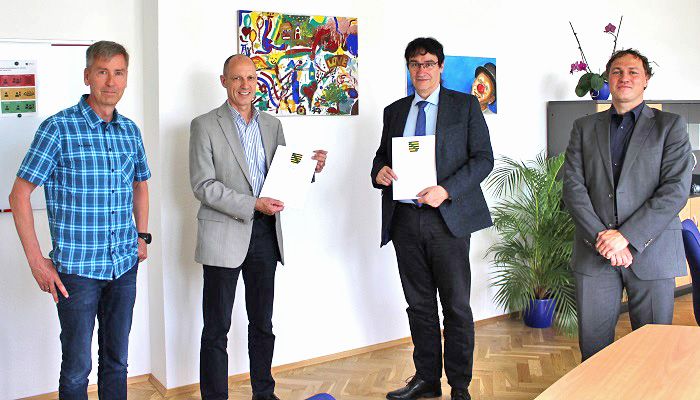Gruppenfoto: 4 Personen. Rektor Kassel mit Vertretetern und Kooperationsurkunde mit der Polizeiverwaltung Sachsen.
