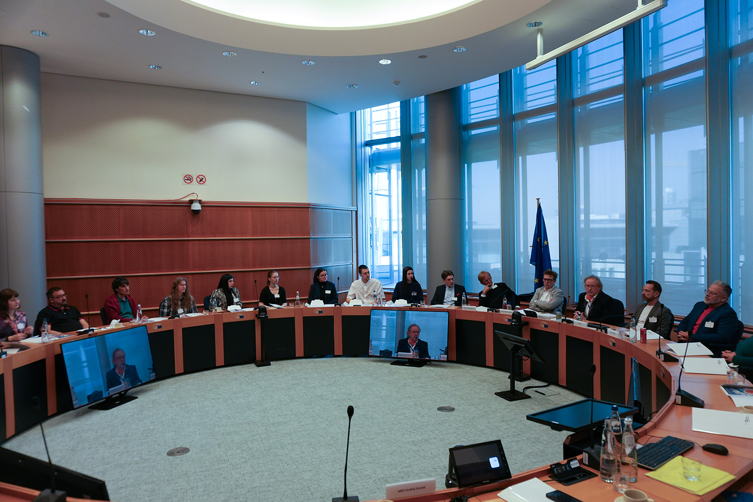 Teilnehmer sitzen an einem runden Tisch und diskutieren. 