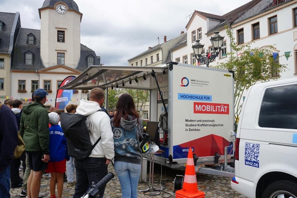 Ein mobiler Zweirad-Prüfstand steht auf dem Marktplatz in Glauchau. Um den Stand stehen viele Personen. 