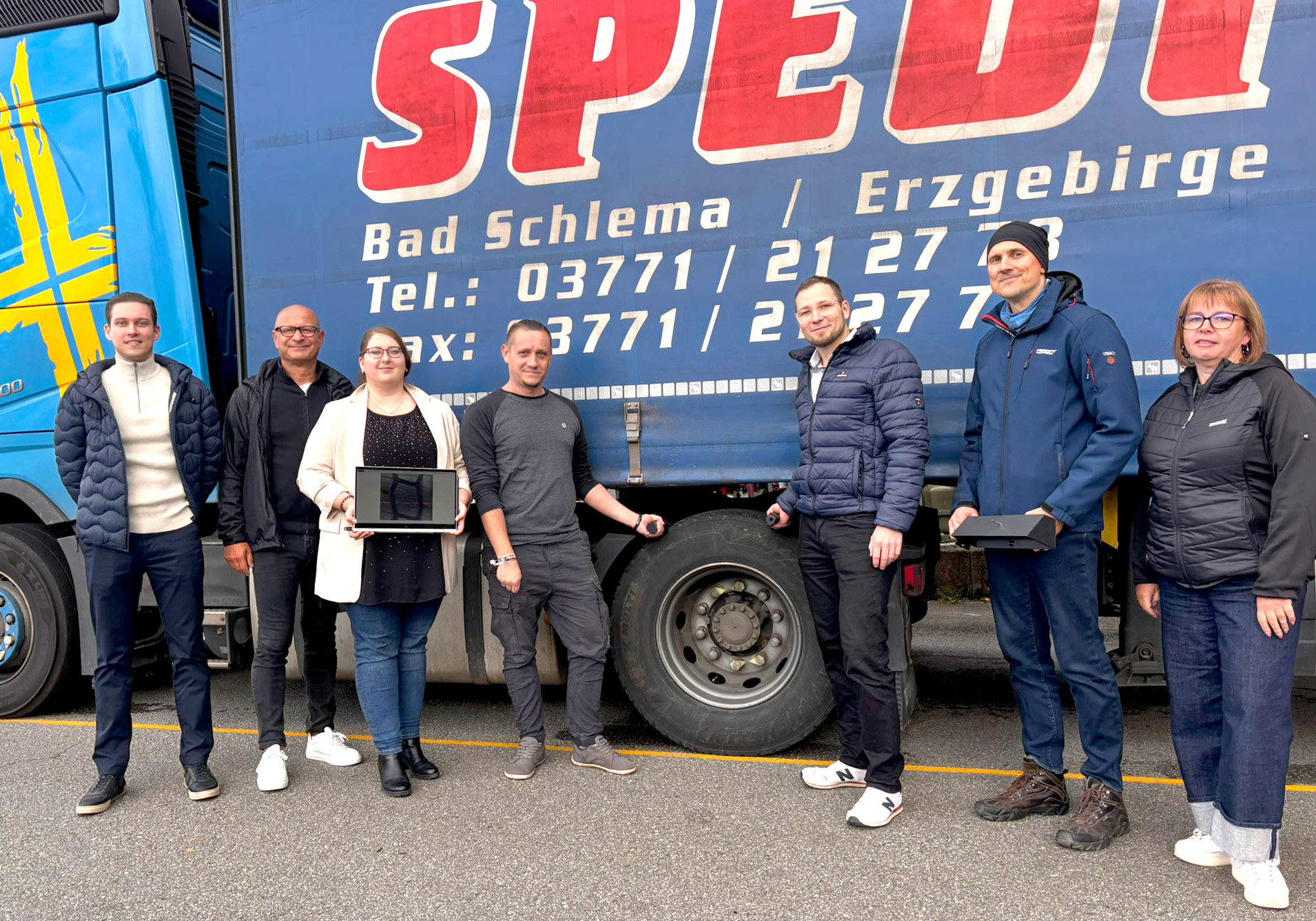 Eine Personengruppe steht vor einem LKW