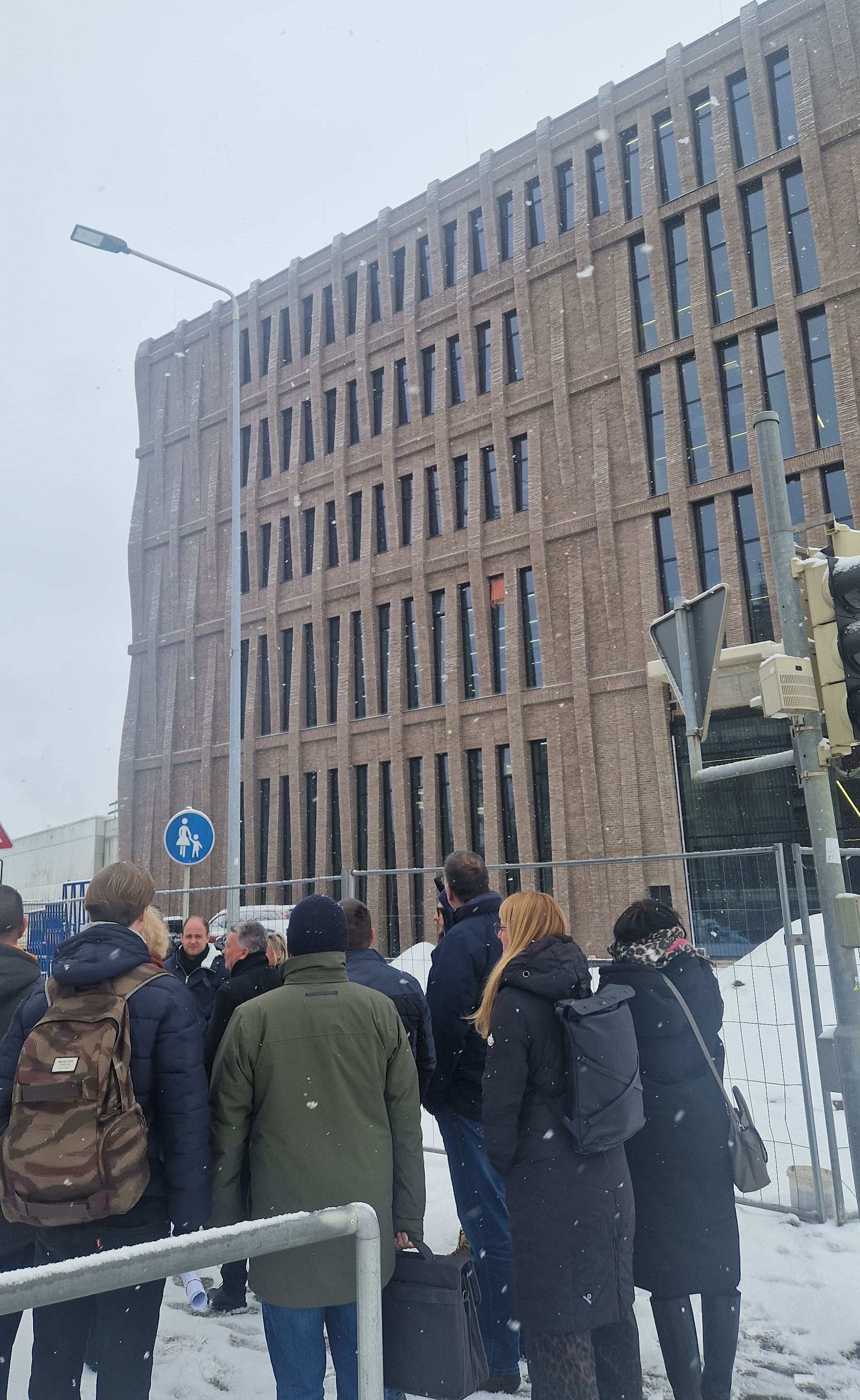 Eine Personengruppe läuft bei Winterwetter auf das neu gebaute TEchnikum der WHZ zu. 