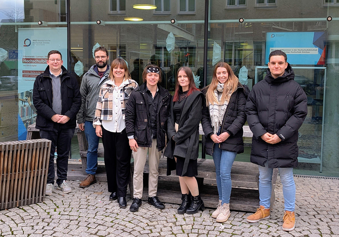 Gruppenfoto von Nachwuchswissenschaftlern und Professoren vor der Hochschulbibliothek. 