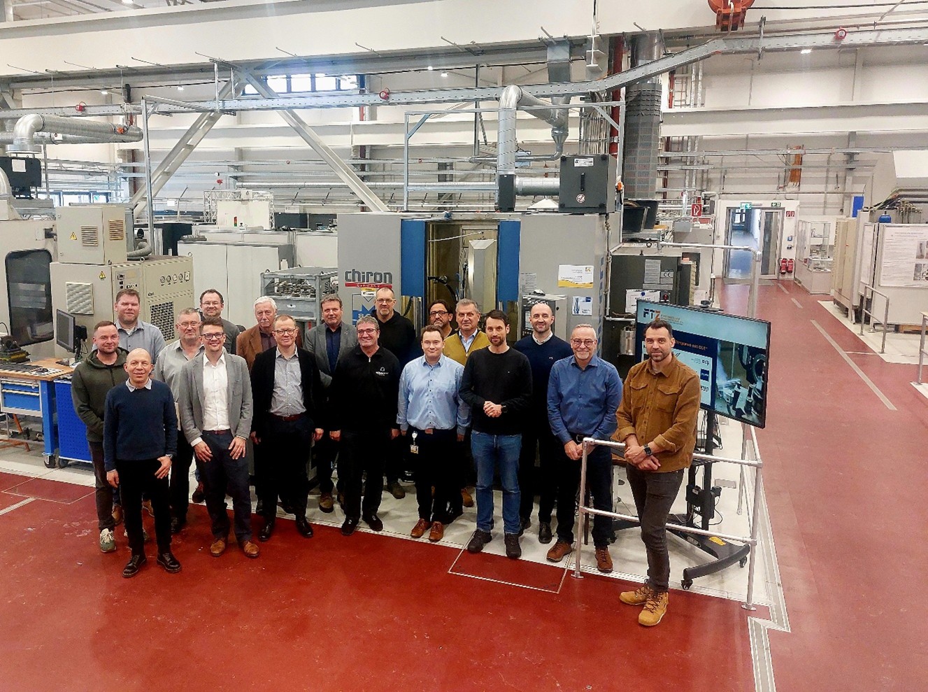 Eine Personengruppe steht in der Maschinenhalle der Fakultät Automobil- und Maschinenbau der WHZ. 