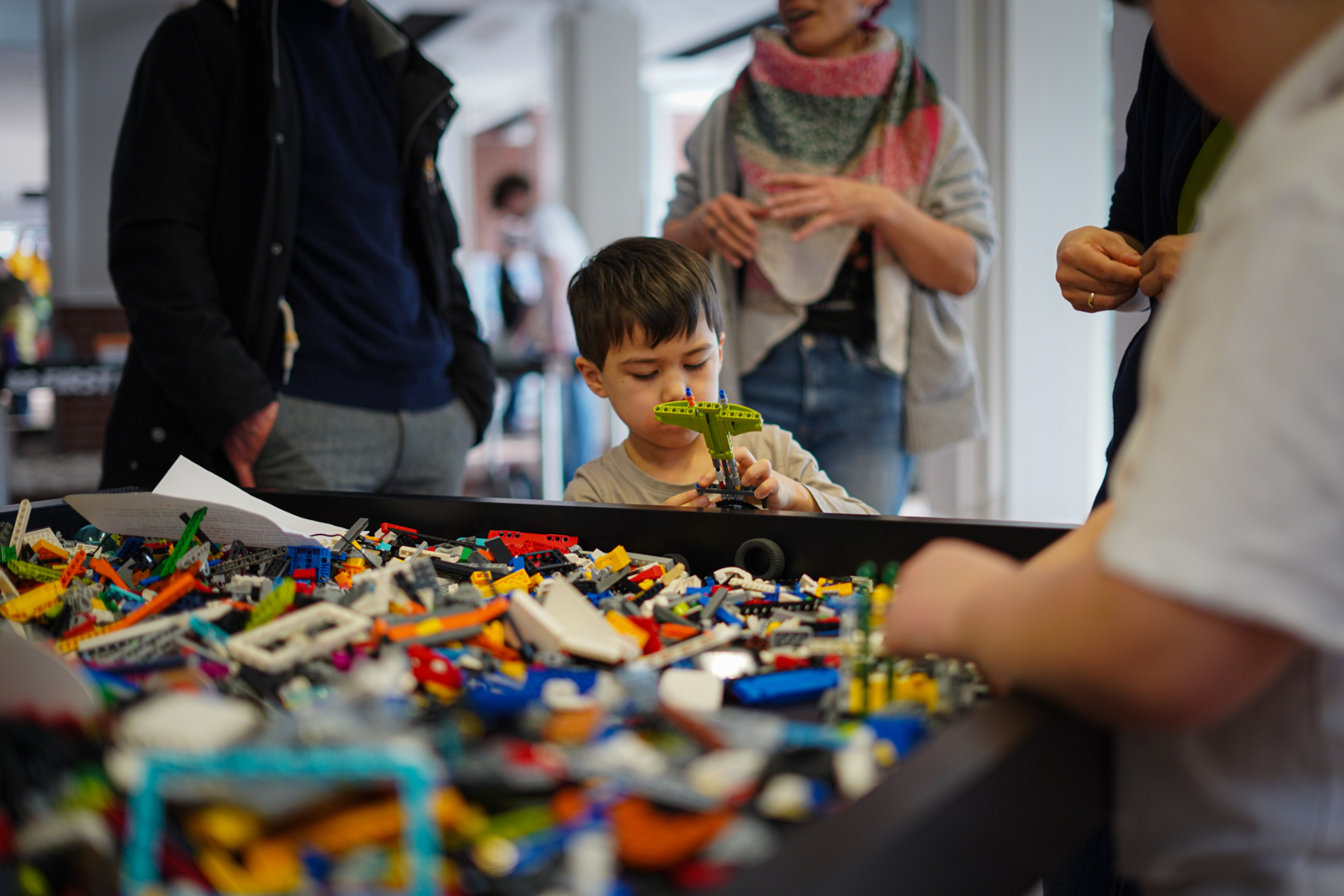 Ein kleines Kind blickt staunend auf ein Set Legosteine.