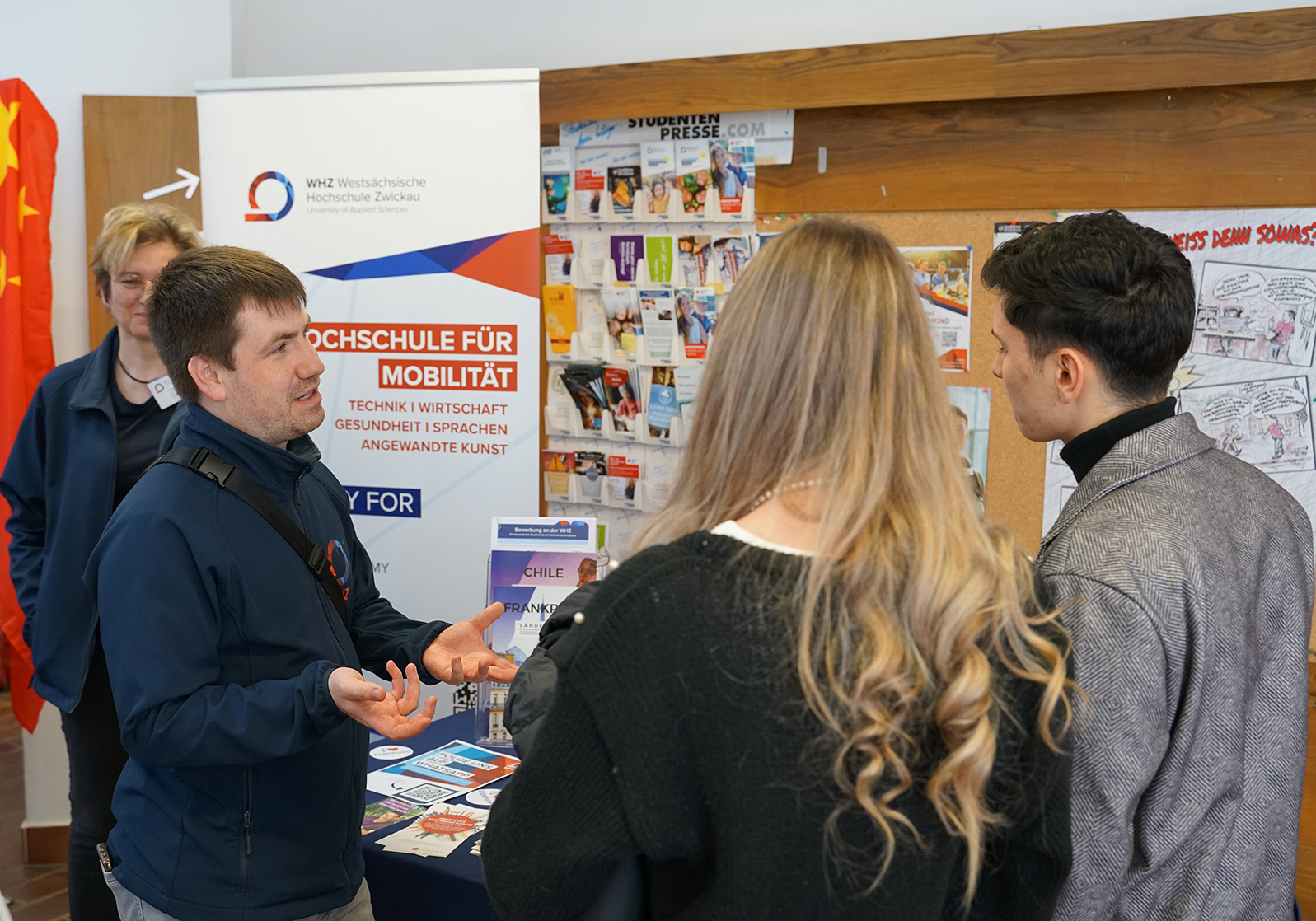 Ein Mitarbeiter im Gespräch mit Studieninteressenten.