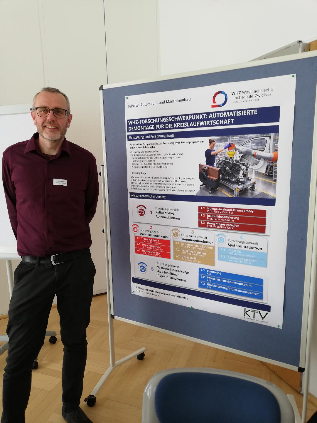 Ein Wissenschaftler steht vor einem Poster