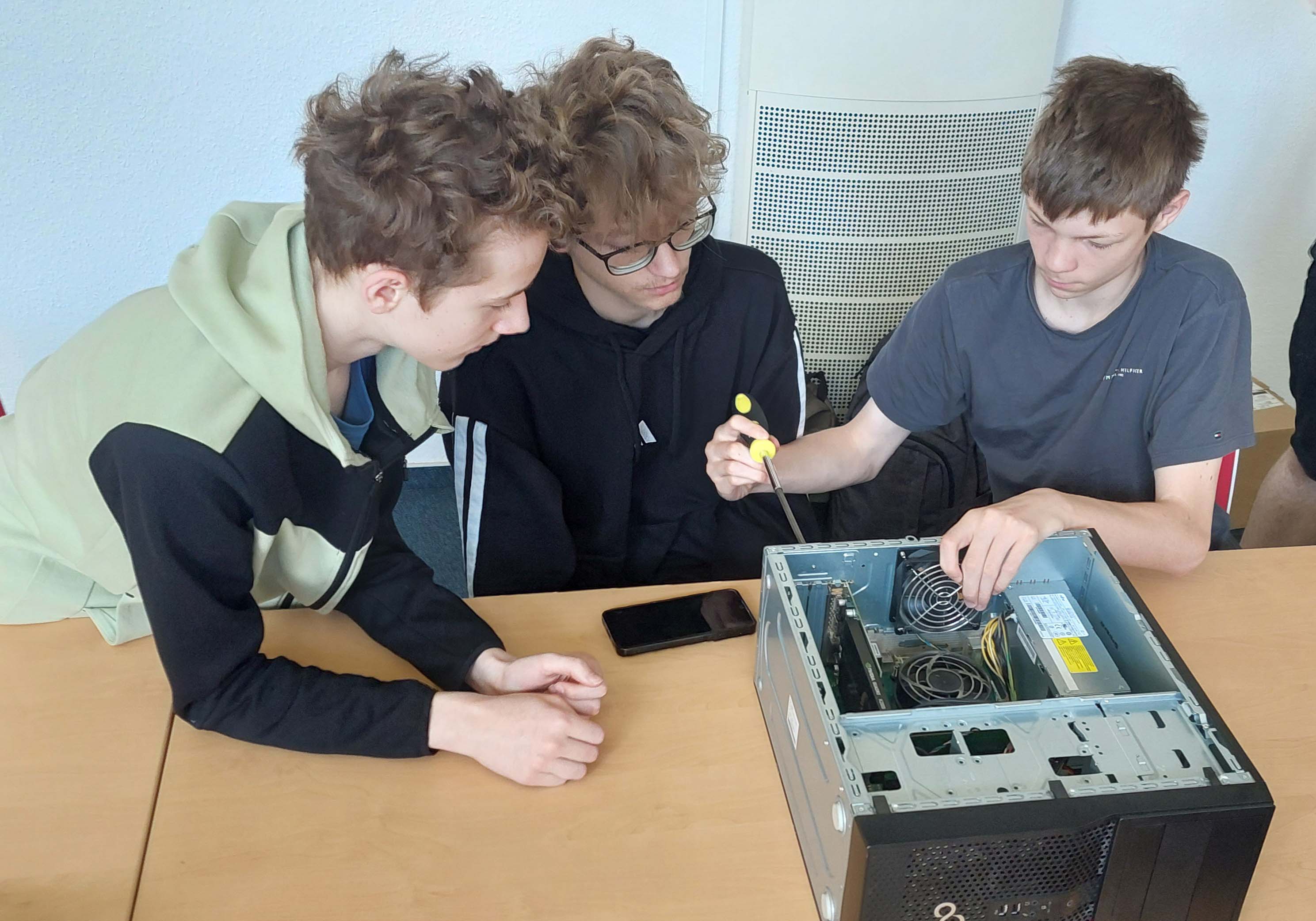 Schüler bauen einen PC auseinander. 